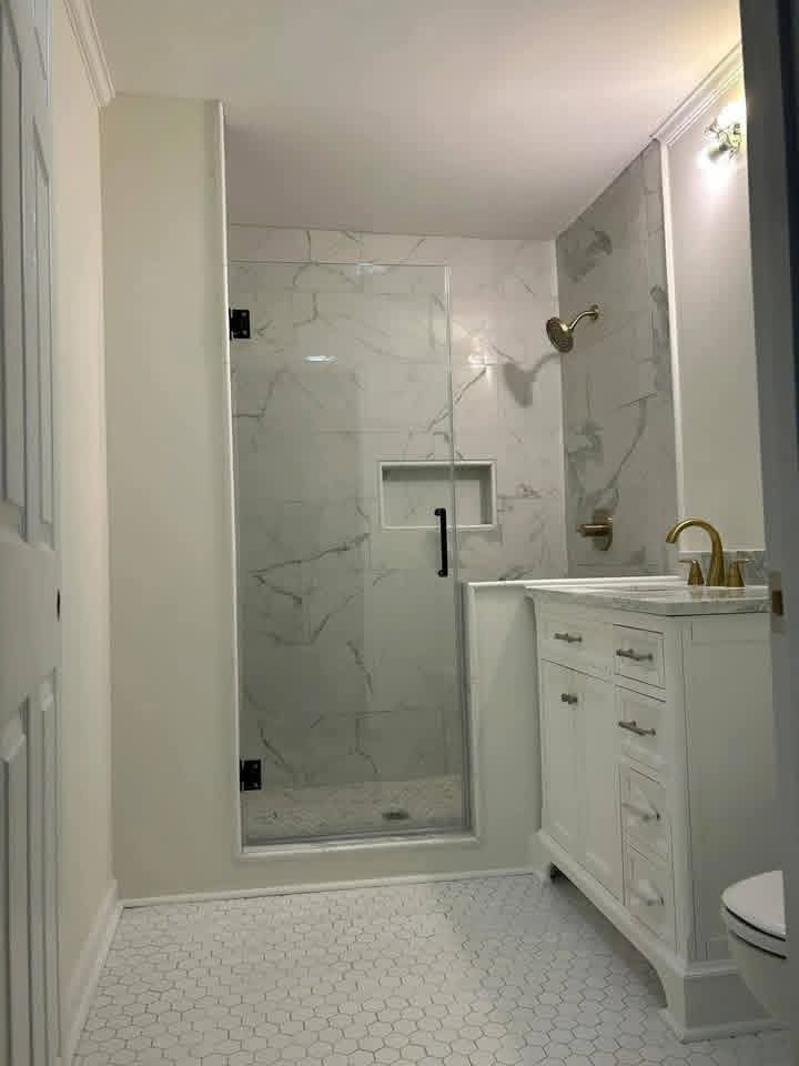 Finished bathroom with glass shower and gold faucet