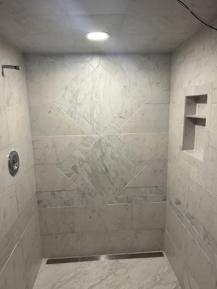Marble walk-in shower with a diamond tile inlay