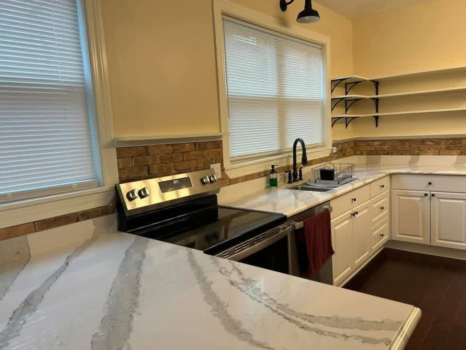 Kitchen stove and sink wall with a brick backsplash